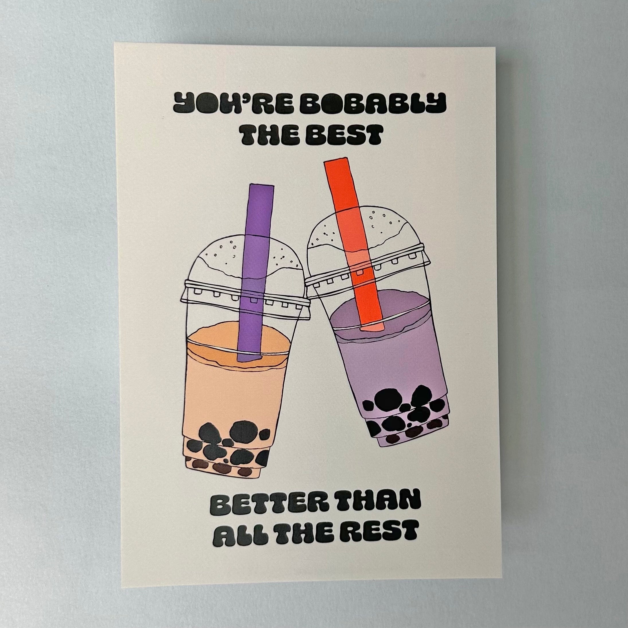 A light coloured notecard with an illustration of two boba tea cups and the text 'YOU'RE BOBAly THE BEST'.