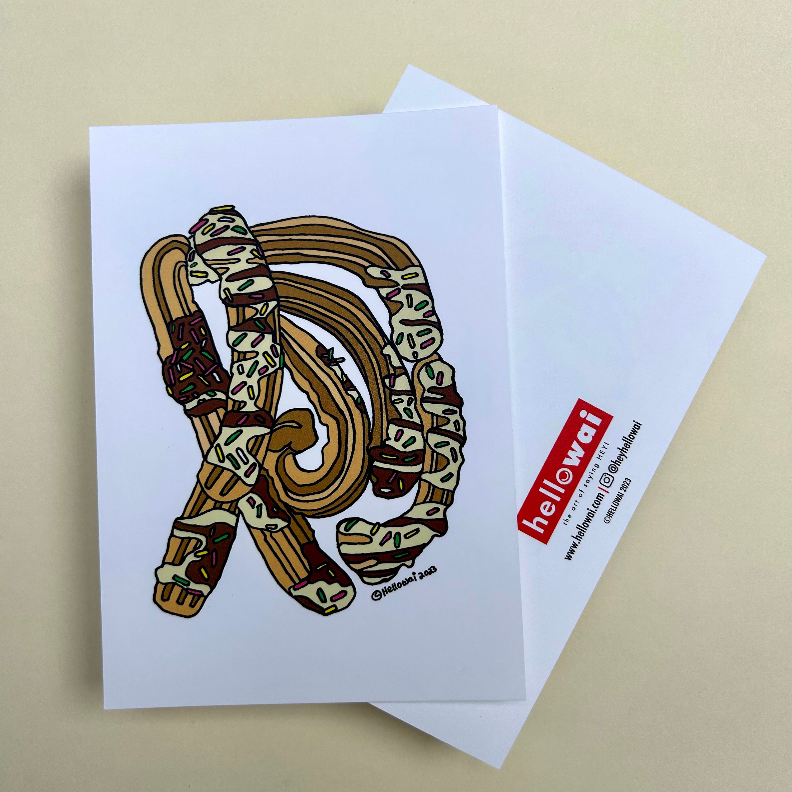 Front and back view of an A6 Hello Wai flat notecard. Front has colour illustration of Churros covered in chocolate sauce and sprinkles on white background. Back has the Hello Wai logo. 