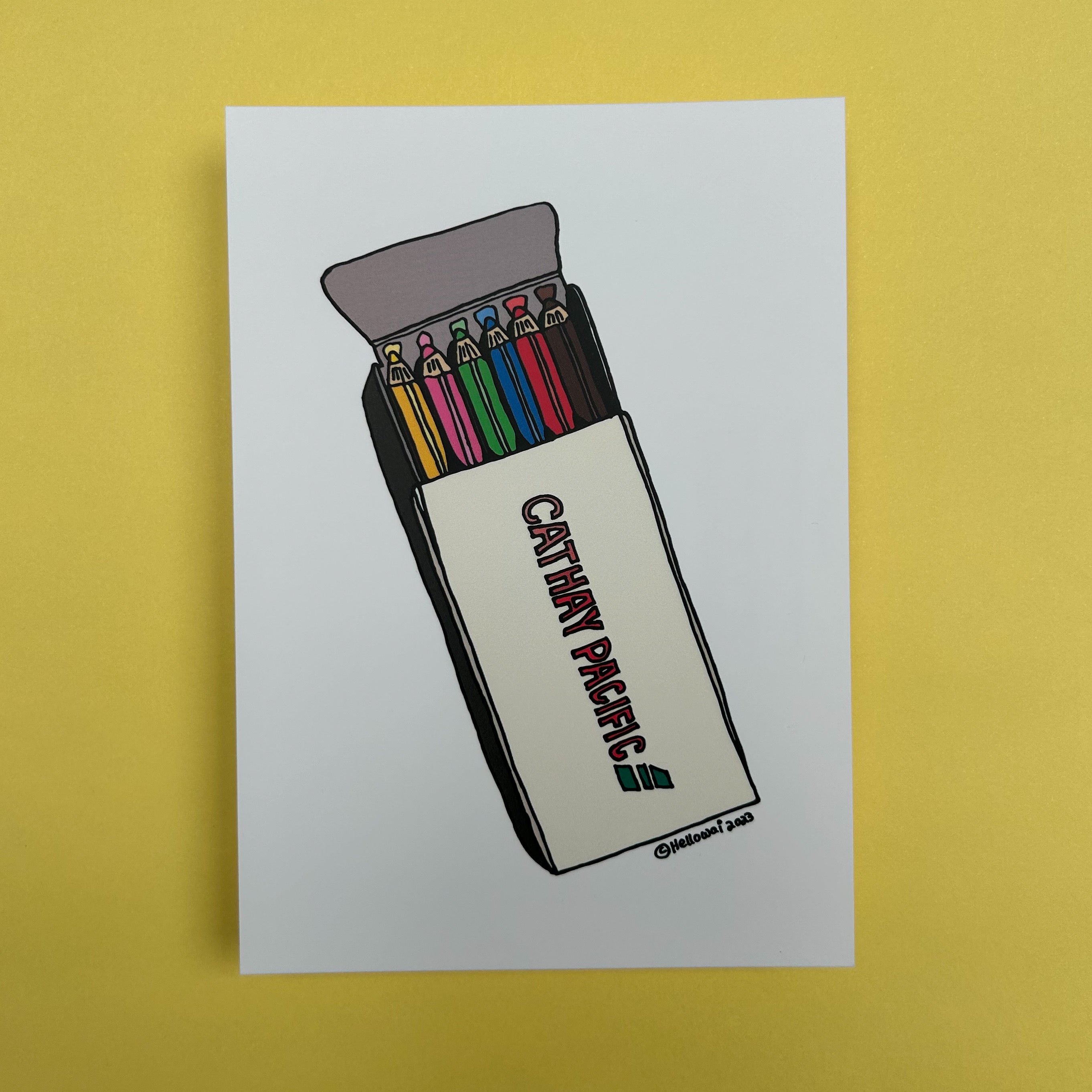 An A6 Hello Wai flat notecard with a colour illustration of an opened box of colouring pencils, printed on white card.