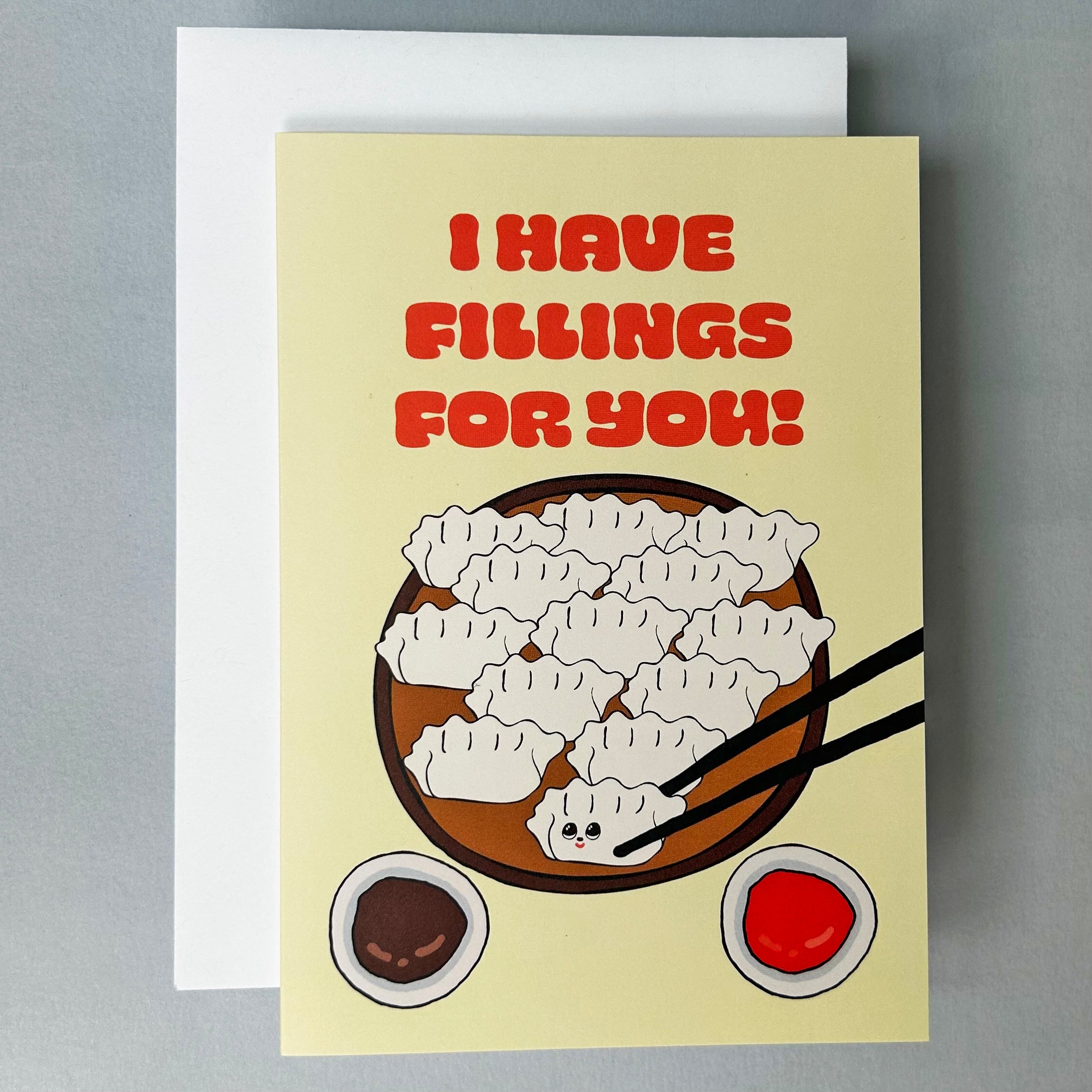 Greeting card with dumplings illustration and text 'I HAVE FILLINGS FOR YOU!' on a beige background.