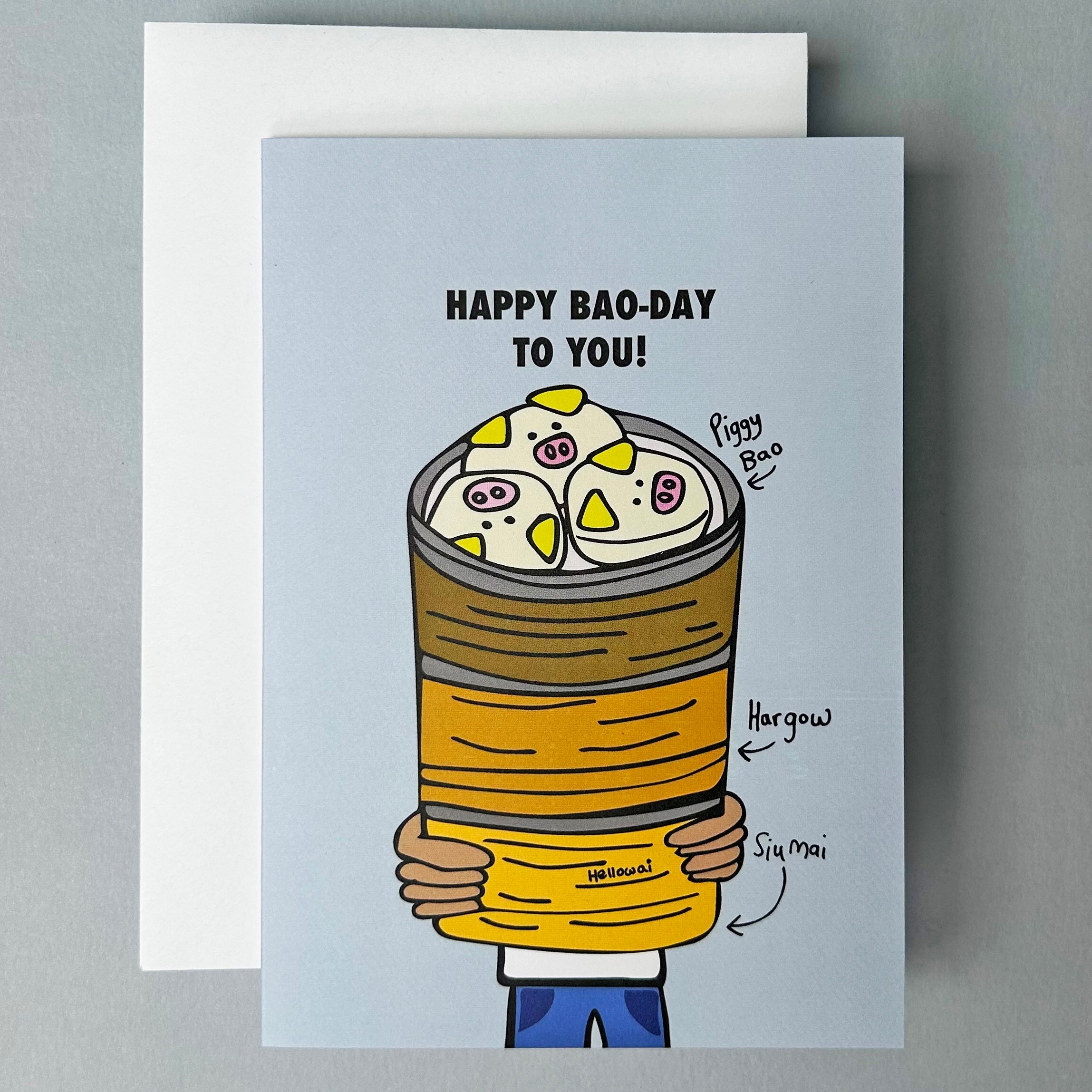 Greeting card with a cartoon illustration of a person holding steamer basket filled with bao with text 'Happy Bao-day to you!' on a gray background.