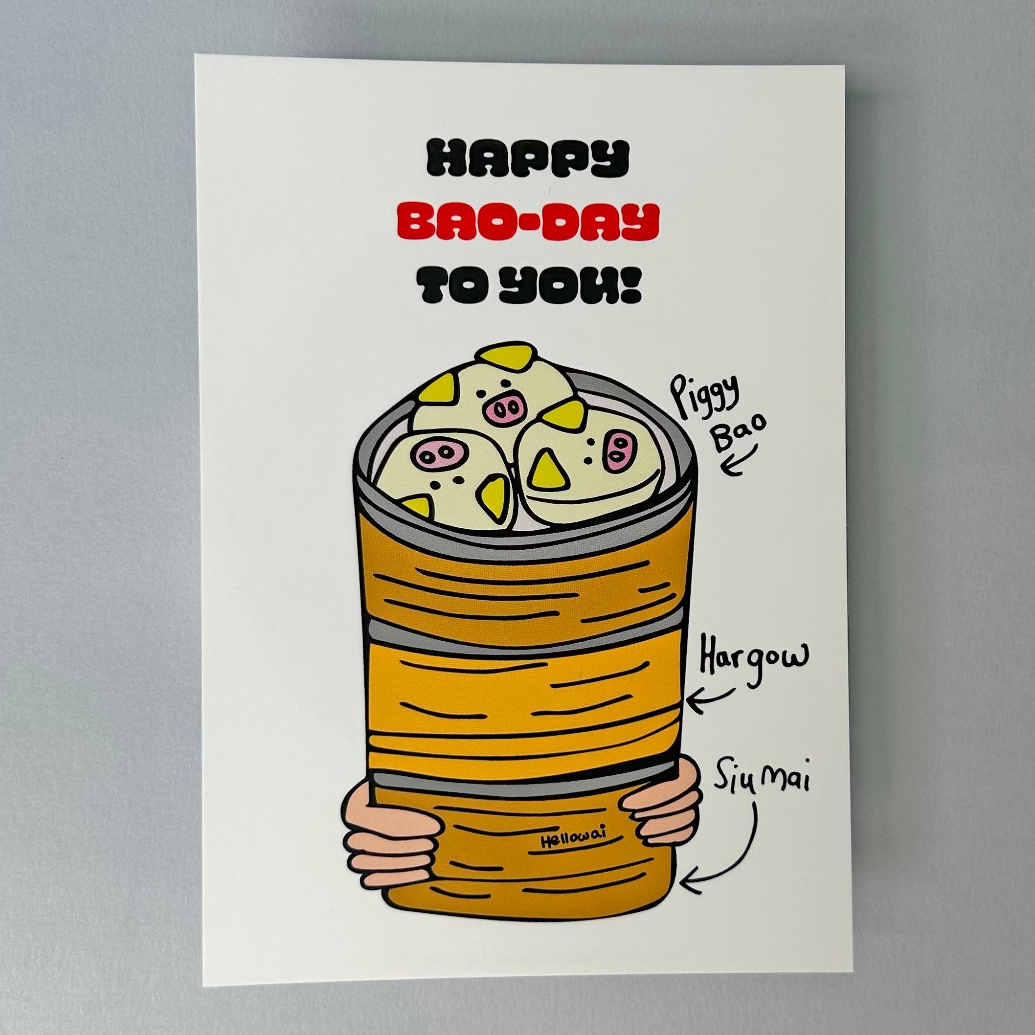 A white notecard with a colourful illustration of three Chinese Bao in a bamboo steamer with the text 'Happy Bao-Day to you!'. 