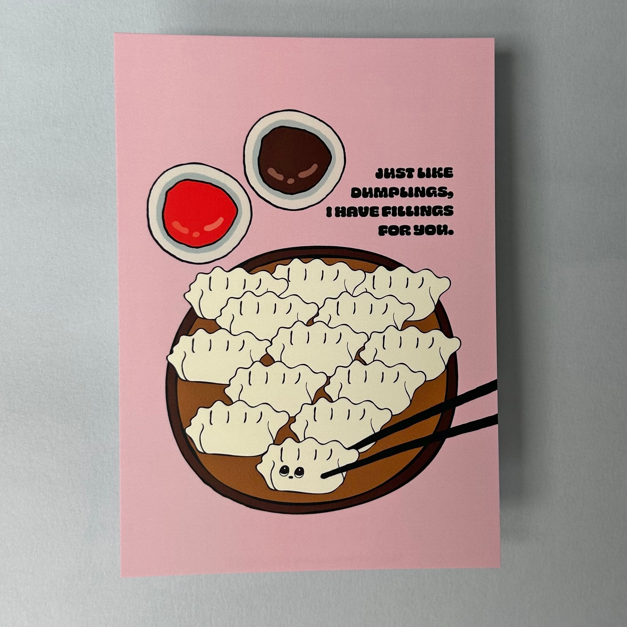 A pink A6 notecard with an illustration of dumplings and text reading 'Just like dumplings, I have fillings for you'. 