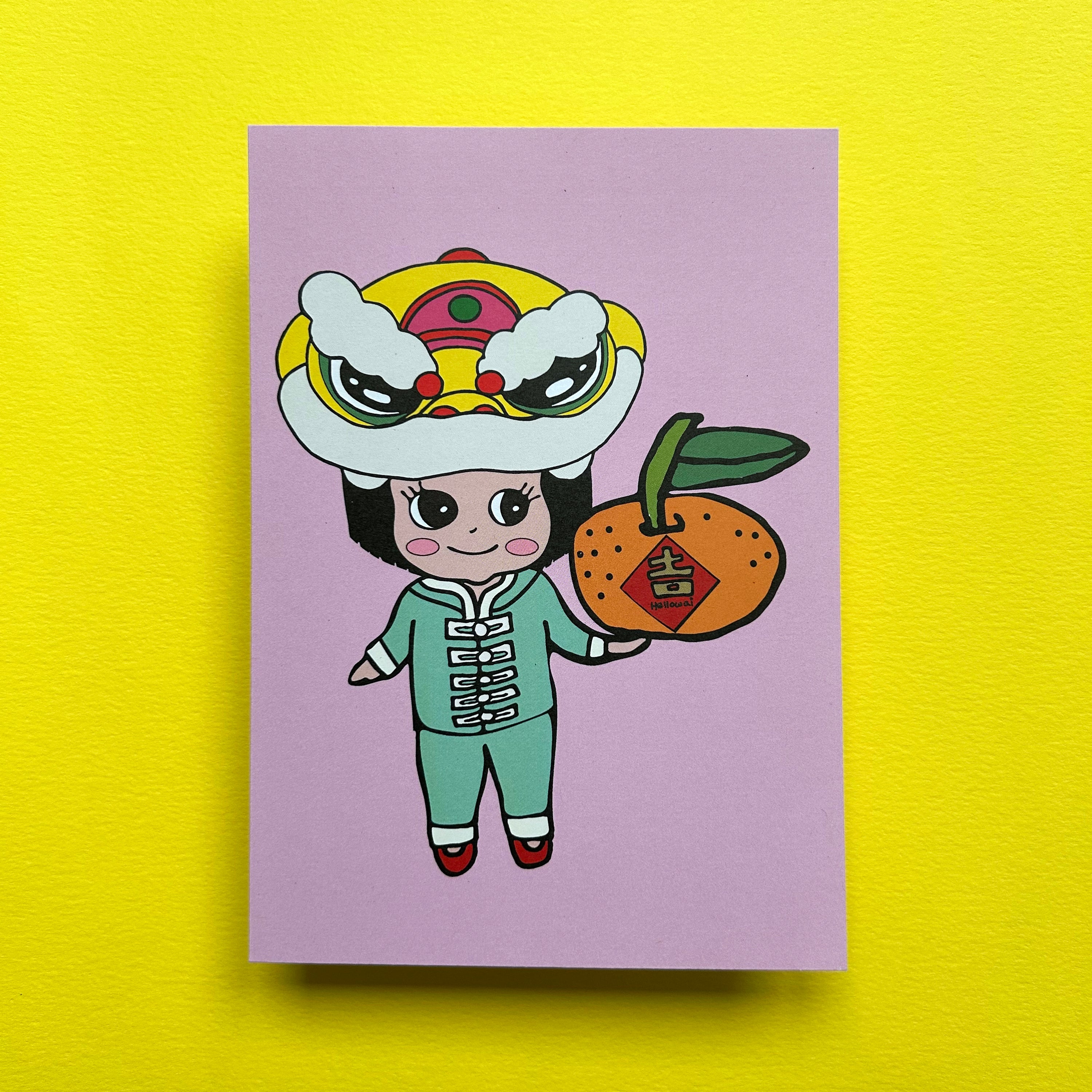 Colour illustration of a girl wearing a Chinese suit, with a Lion Head on her head and holding a large tangerine, printed on a light coloured card. 