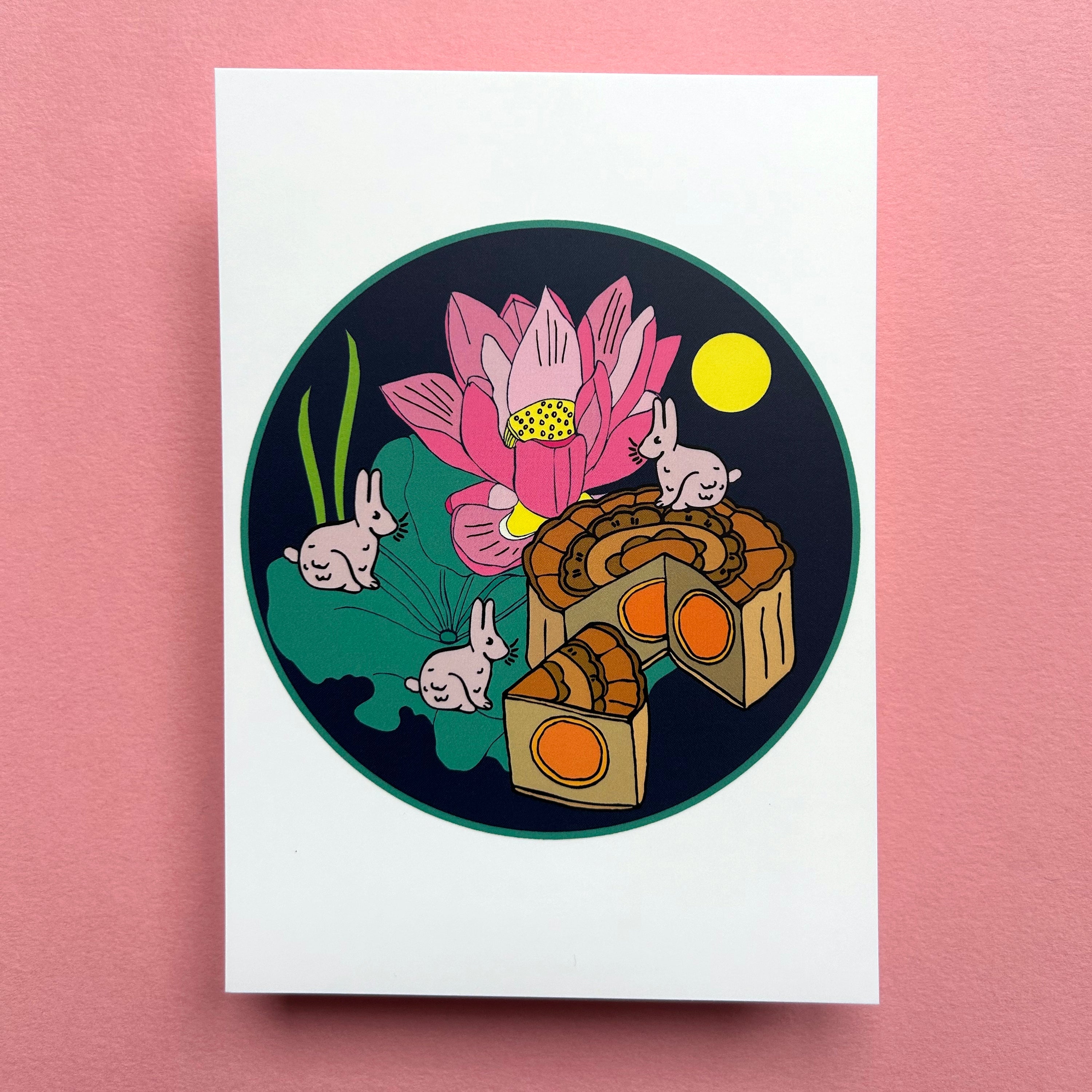 Illustration of a pink lotus flower, mooncakes, and rabbits on a white card with a pink background