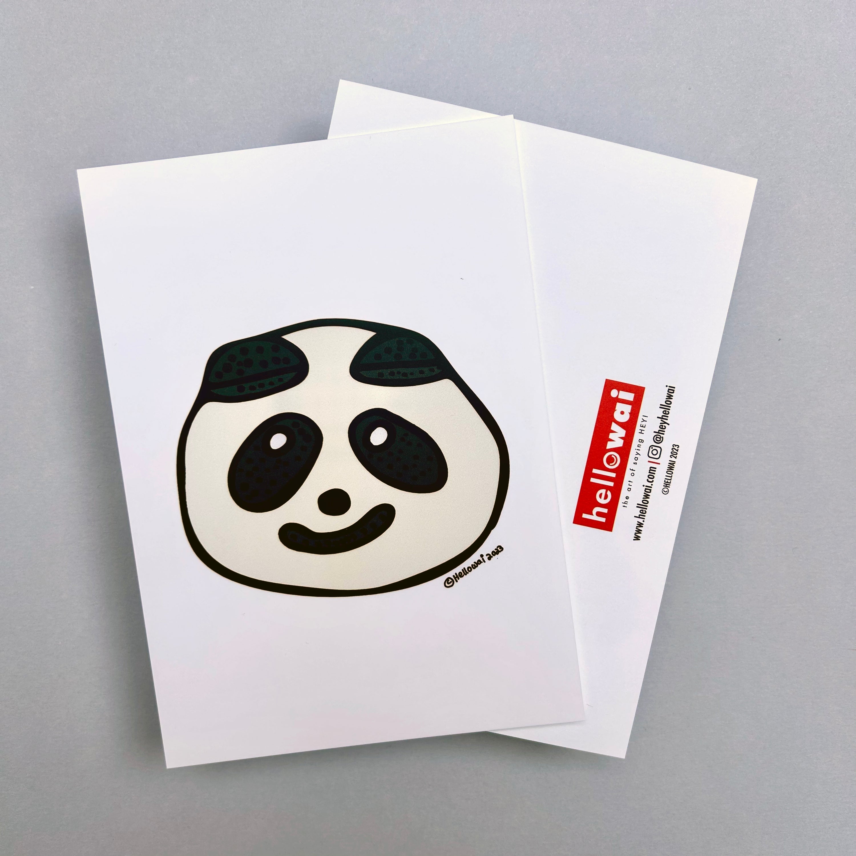 Front and back view of an A6 Hello Wai flat notecard. Front has colour illustration of a cute panda shaped bao, printed on white card. Back has the Hello Wai logo.