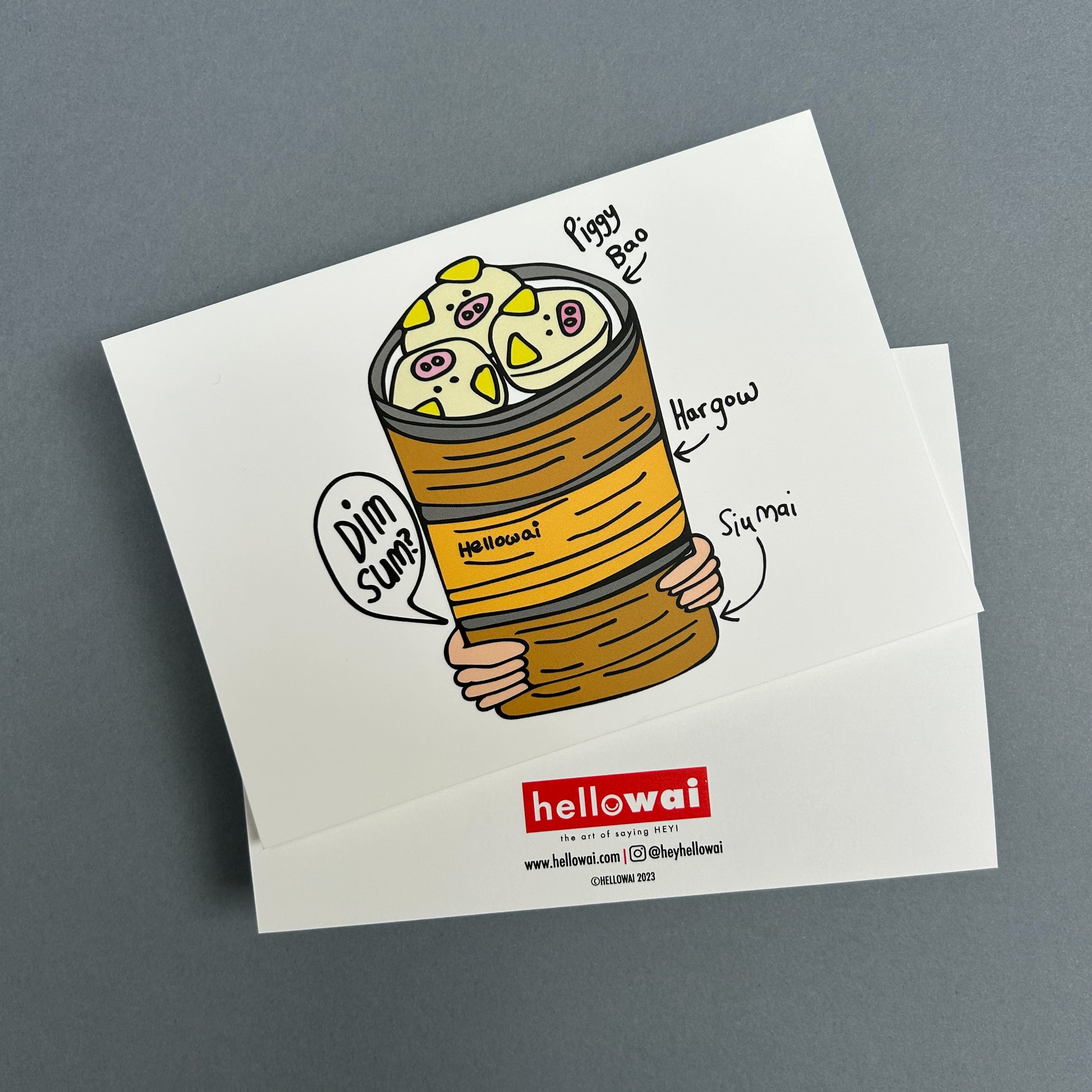 Front and back view of an A6 Hello Wai flat notecard. Front has colour illustration of pair of hands carrying three bamboo baskets stacked with dim sum, the top basket has Piggy Bao. Back has the Hello Wai logo.