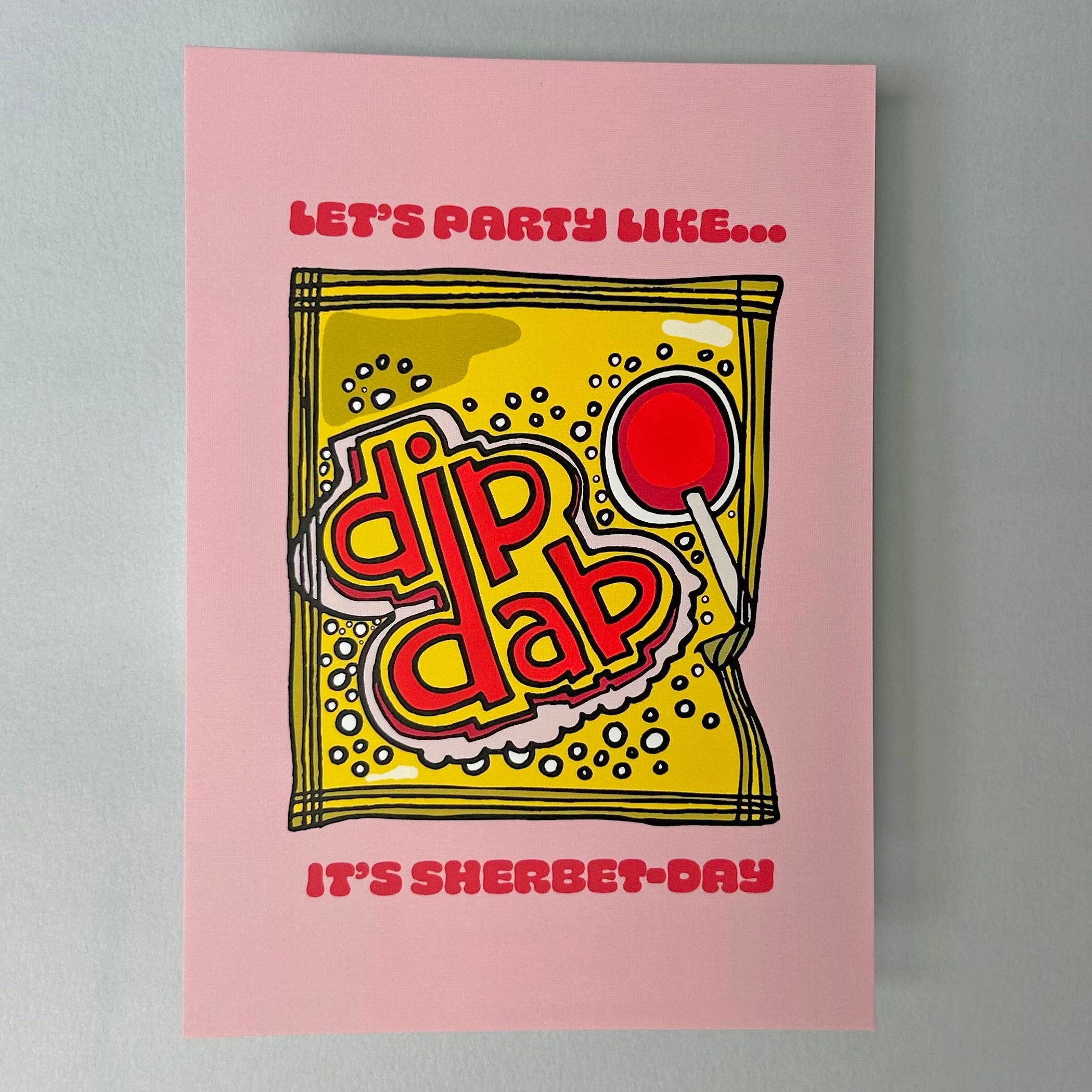 An A6 note card with illustration of retro sweet packet  and text "Let's Party Like..." on a pink background