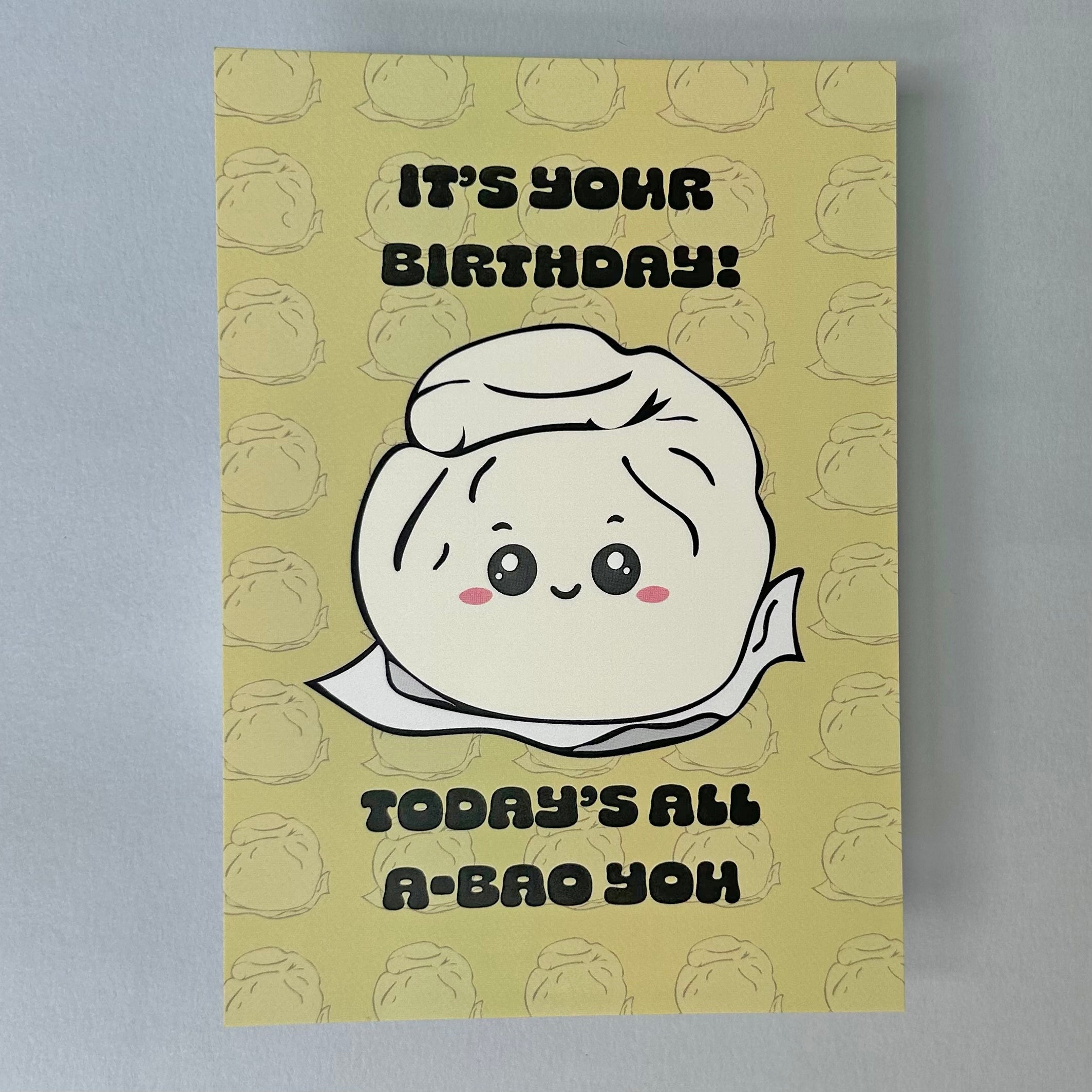 A lnotecard with a bao-themed illustration, featuring text 'It's your birthday! Today's all a-bao you!' with a faded  bao pattern in the background. 